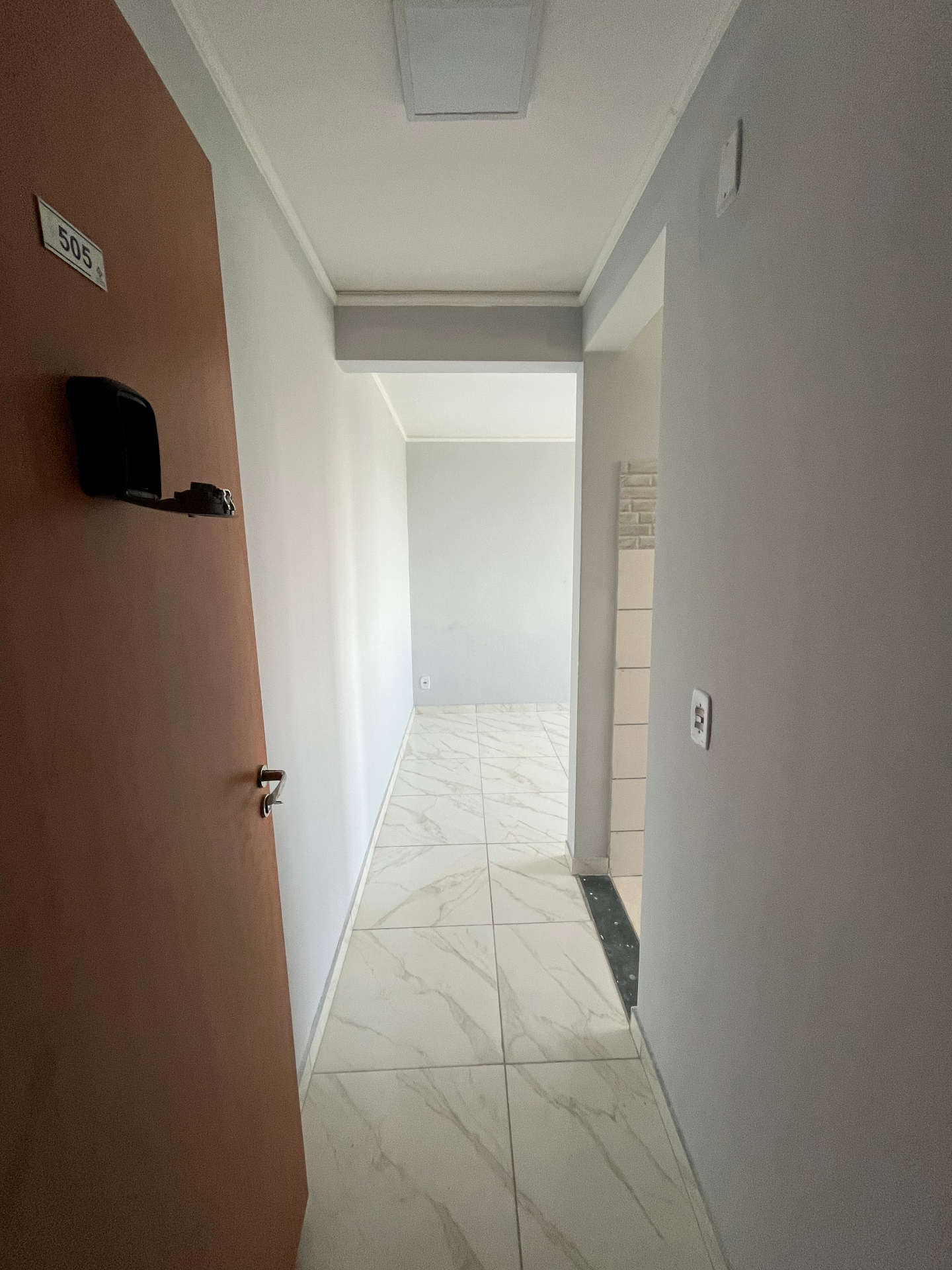 Entrada do apartamento com corredor e piso claro