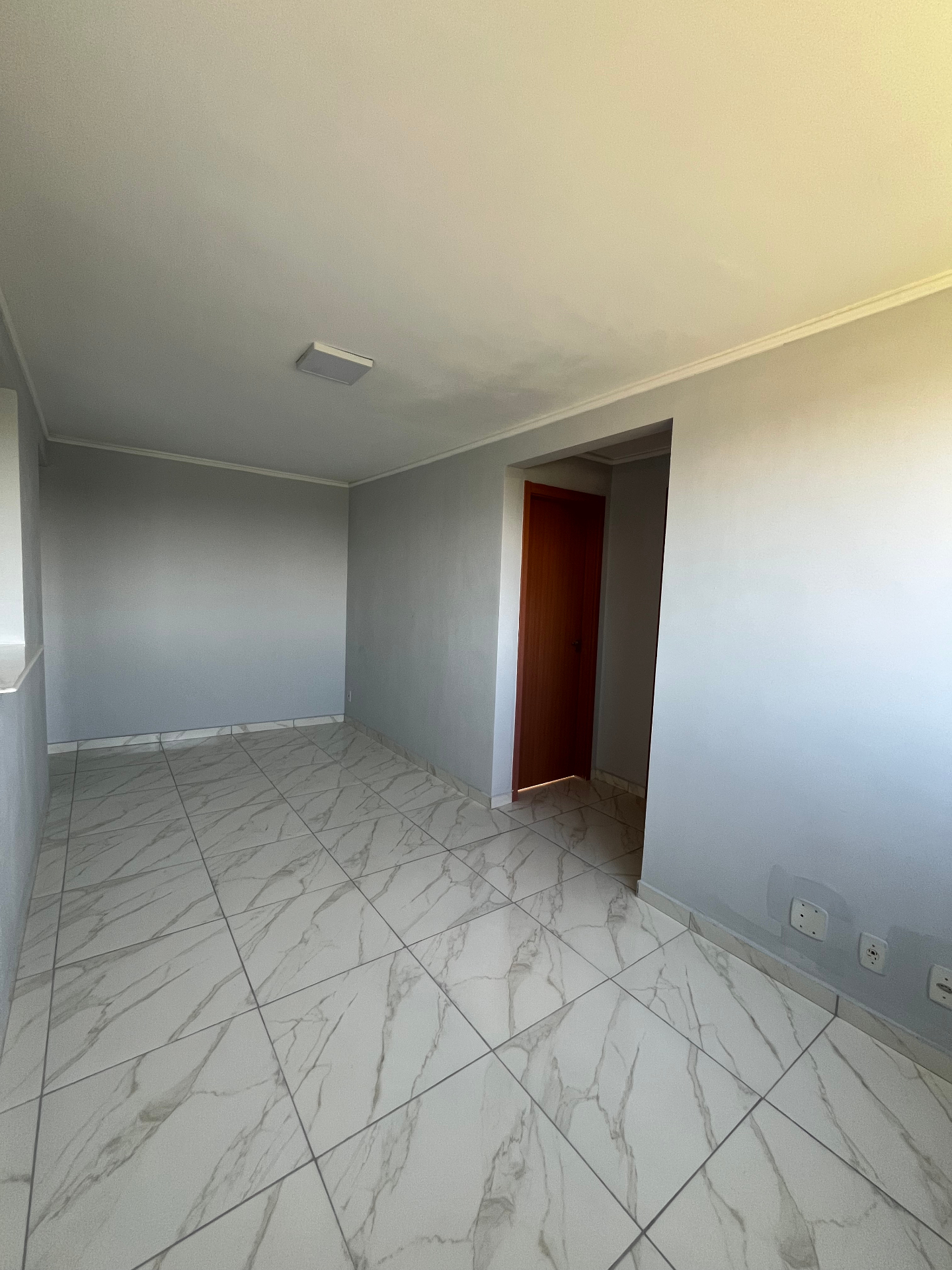 Sala com piso marmorizado e paredes claras